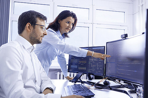 Two Leadec employees planning automation solutions on the computer.