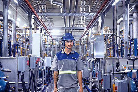 Leadec employee walking on shopfloor of Food & Beverage factory. 